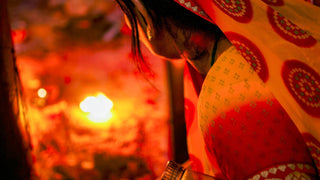 Rajasthani woman praying before temple flame during Savitri festival, Pushkar